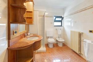 a bathroom with a sink and a toilet at Terrazza Valtellina in Grosio +23 photos
