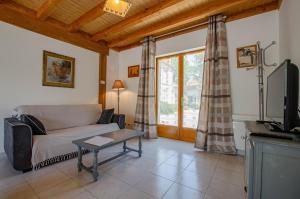 a living room with a couch and a tv at Les prés saint jean in Champigny-sur-Aube