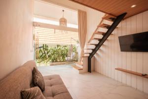 a living room with a couch and a staircase at Santai Studios in Badung