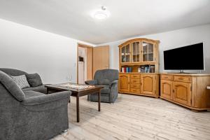 a living room with two chairs and a flat screen tv at Ferienwohnung bis zu 6 Per. 65 M² in Wolgast
