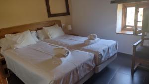 two beds with white sheets and a teddy bear on them at La Casa Laste in Casas de Esper +21 photos
