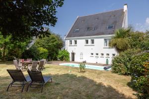 a house with chairs and a table and a pool at La parenthèse Océane -Avec piscine in Concarneau