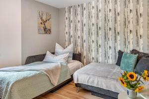 a bedroom with a bed and a couch and a vase of flowers at Weinbergschnecke Ferienwohnung in Efringen-Kirchen