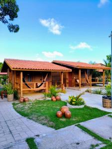 a wooden house with pumpkins in the yard at POUSADA ALLES in Santo Amaro