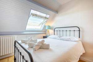 a bedroom with a bed with white sheets and a window at La parenthèse Océane -Avec piscine in Concarneau +26 photos