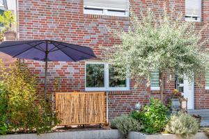 a blue umbrella in front of a brick building at Weinbergschnecke Ferienwohnung in Efringen-Kirchen