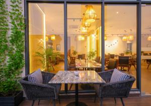 a dining room with tables and chairs and windows at Rhythm Gurugram, Hotel & Suites, Sohna Road, Sector 68 in Gurgaon