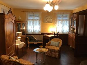 a living room with chairs and a table and windows at Villa Merzbach - Wohnen wie im Museum mit Komfort in Untermerzbach