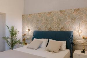 a bedroom with a bed with a blue headboard at Perla Apartments in Agia Pelagia