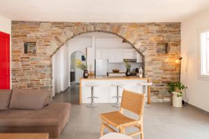 an open kitchen and living room with a brick wall at Nalo Suites & Villas in Kithnos