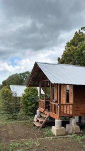 a small wooden cabin with a metal roof at Kuna GlampCamp in Gitgit