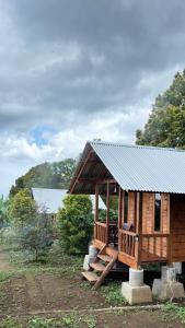 a wooden cabin with a metal roof at Kuna GlampCamp in Gitgit