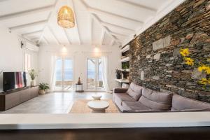 a living room with a couch and a brick wall at Nalo Suites & Villas in Kithnos