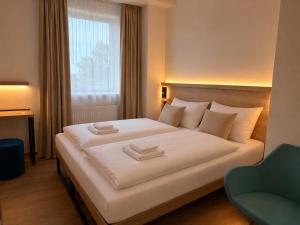 a hotel room with a bed and a chair at Pension Klatovy in Klatovy