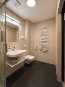 a bathroom with a sink and a toilet and a mirror at Pension Klatovy in Klatovy