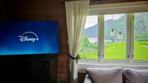 a flat screen tv in a room with a window at Romantic farmhouse in Vaksdal