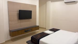 a bedroom with a bed and a tv on a wall at The Kashi Dharohar in Varanasi