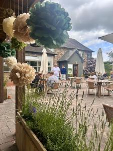 a group of people sitting at tables in a patio at The Baiting House in Upper Sapey