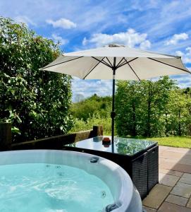 an umbrella sitting next to a hot tub at The Baiting House in Upper Sapey