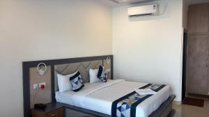 a bedroom with a large bed with blue and white pillows at The Kashi Dharohar in Varanasi