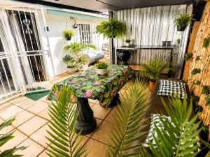 a patio with a table and a bunch of potted plants at WHY NOT GUESTHOUSE in Bothaville