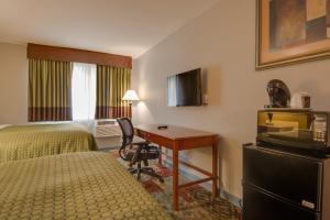 a hotel room with a desk and a bed and a desk at Vagabond Inn Executive Hayward in Hayward