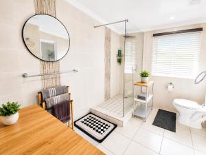 a bathroom with a shower and a table and a mirror at WHY NOT GUESTHOUSE in Bothaville +6 photos