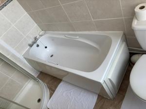 a white bath tub in a bathroom next to a toilet at Whitecliff View in Sandown +23 photos