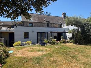 a large white house with a large yard at Les Terrasses de Rostevel in Brech
