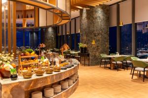 a buffet line in a restaurant with tables and chairs at Steigenberger Phnom Penh in Phnom Penh