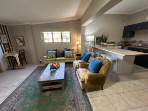 a living room with two couches and a table at Mariri Farm Cottage in Patentie