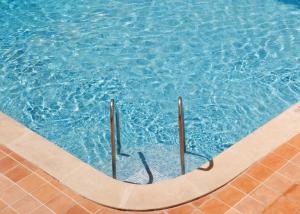 a swimming pool with blue water and poles in it at Hotel Cassandra in El Arenal