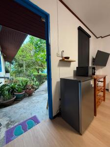 a kitchen with a refrigerator and a sliding glass door at Blue Privacy Resort in Nathon Bay