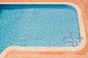 an empty swimming pool with two chairs in it at Hotel Cassandra in El Arenal +48 photos