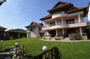 a large house with a green lawn in front of it at Ionela in Costinesti