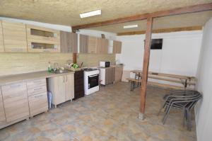 a kitchen with wooden cabinets and a table and chairs at Ionela in Costinesti
