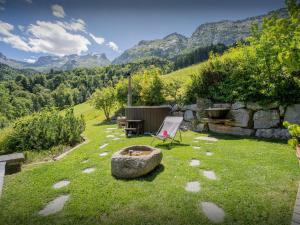 a chair and a table in a yard with mountains at Lodge La Source - OVO Network in Les Clefs