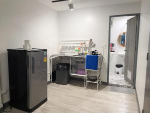 a kitchen with a black refrigerator and a table at MAXi MaMa Room in Bangkok