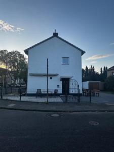 a white building with a fence in front of a street at Gästehaus OG in Cologne +18 photos