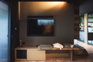a living room with a table and a tv on the wall at Chalet Tefiti in Romeno