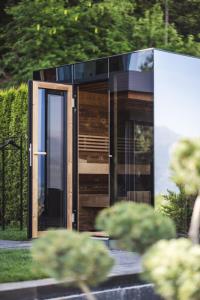 a building with a glass door in a garden at Chalet Tefiti in Romeno