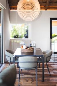 a dining room with a table with chairs and a chandelier at Chalet Tefiti in Romeno +4 photos