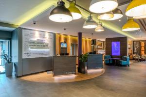 a lobby with a large screen in the middle at Premier Inn Göttingen in Göttingen +57 photos