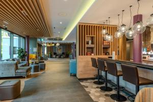 a hotel lobby with a bar and chairs at Premier Inn Göttingen in Göttingen