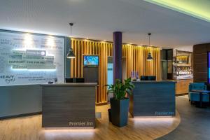a hotel lobby with a reception desk and a large screen at Premier Inn Göttingen in Göttingen