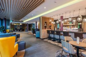 a restaurant with tables and chairs and a bar at Premier Inn Göttingen in Göttingen