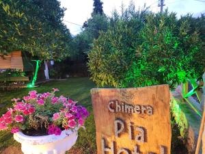 a sign in a yard with a pot of flowers at Chimera Pia Aparts in Cıralı +71 photos