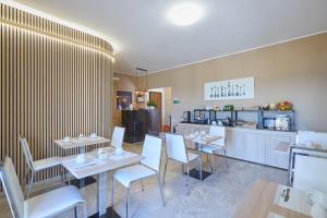 a restaurant with white tables and chairs and a counter at La Zagara Rooms - Porto di Milazzo in Milazzo +17 photos