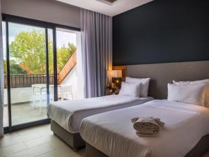 a hotel room with two beds and a balcony at ZEPHYR Ifrane in Ifrane +25 photos