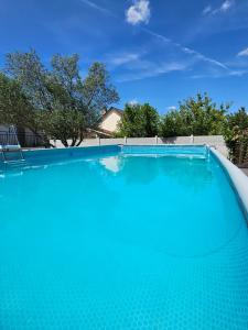 a large swimming pool with blue water at Appartement T2 confortable - ParisGetAway95 in Pierrelaye